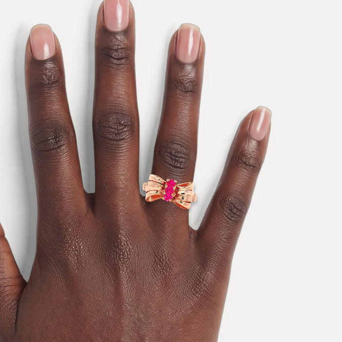 Deep Red Ruby Bow Ring (¾ ct. tw.) in 14k Rose Gold shown on a hand (deep skin tone)