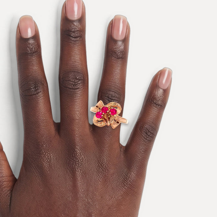 Vintage Three-Stone Art Deco Ruby Ring (⅓ ct. tw.) in 14k Rose Gold shown on a hand (deep skin tone)