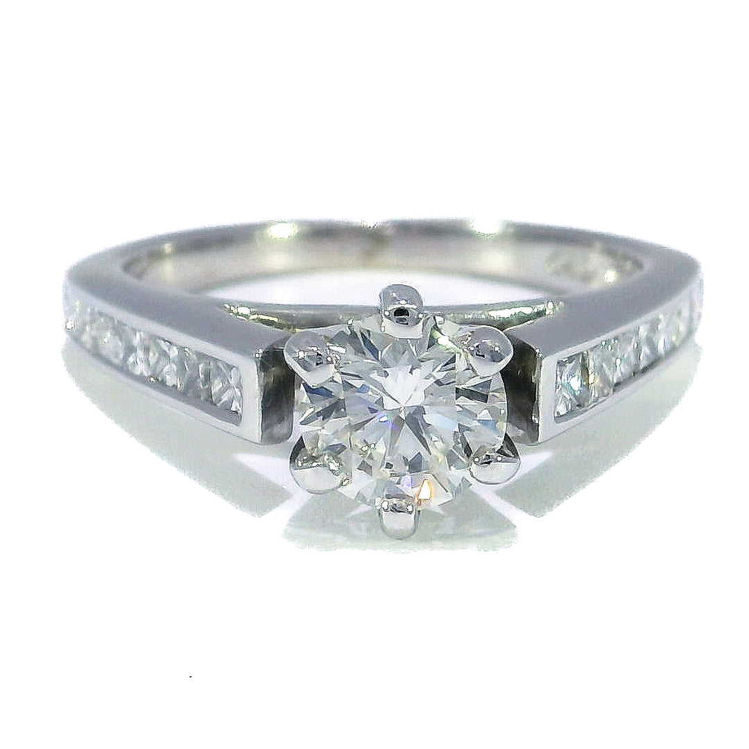 An 18KT white gold engagement ring featuring a round brilliant cut diamond with smaller diamonds on the band.