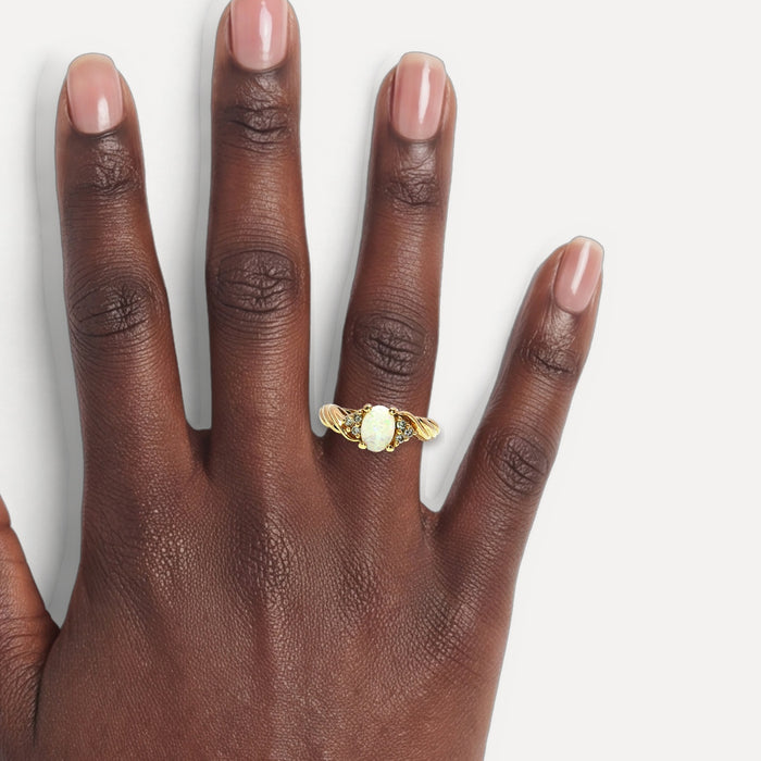 Colorless & Near-Flawless Oval Opal & Diamond Ring (½ ct. tw.) in 14k Yellow Gold shown on a hand (deep skin tone)