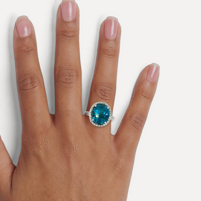 Oval-Shaped Deep London Blue Topaz & Colorless Diamond Halo Ring (7 ¼ ct. tw.) in 14k White Gold shown on a hand (medium deep skin tone)