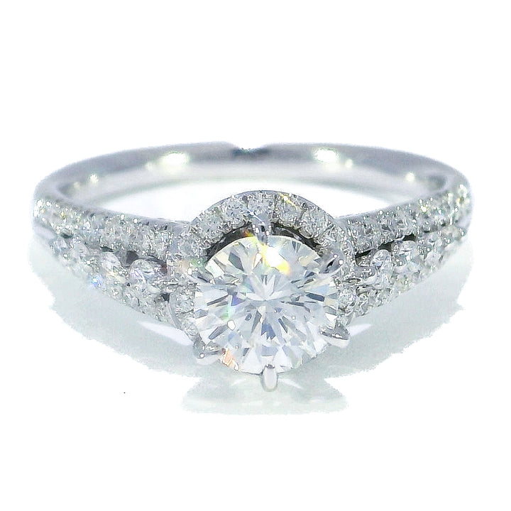 A round brilliant cut diamond engagement ring with a halo effect, set in a white gold band.