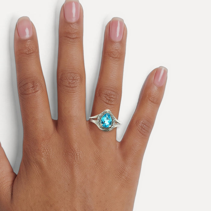 Pear Shape Aquamarine Blue CZ Halo Ring in Sterling Silver shown on a hand (medium deep skin tone)