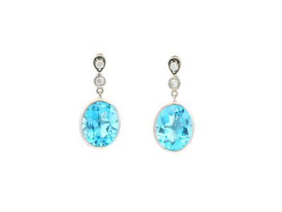 Pair of silver dangle earrings with oval blue gemstones and round clear stones