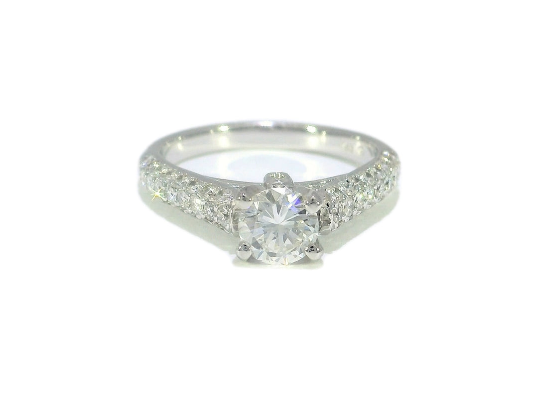 A round brilliant diamond engagement ring set in a 14KT white gold band with diamond-covered mounting.