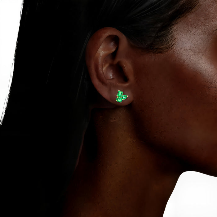 Three-Stone Vivid Colombian Emerald Stud Earrings (1 ¾ ct. tw.) in 18k Yellow Gold shown on the ear (deepest skin tone)