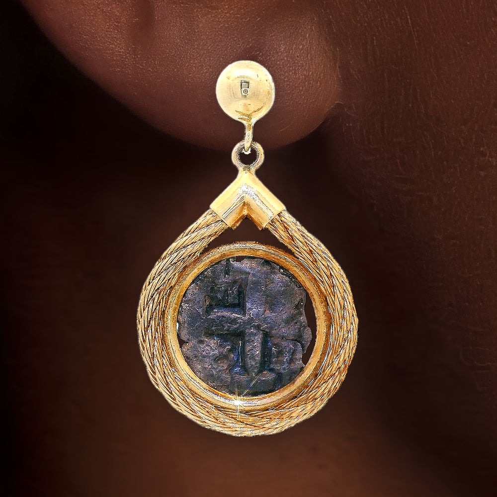 Vintage Spanish Shipwreck Coin Cross Dangle Earrings in 14k Yellow Gold shown on the ear (deep skin tone)