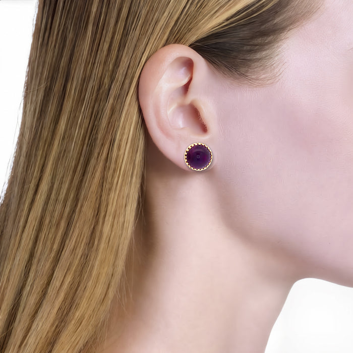 Deep Amethyst Cabochon Stud Earrings (16 ½ ct. tw.) in 14k Yellow Gold shown on the ear (light skin tone)