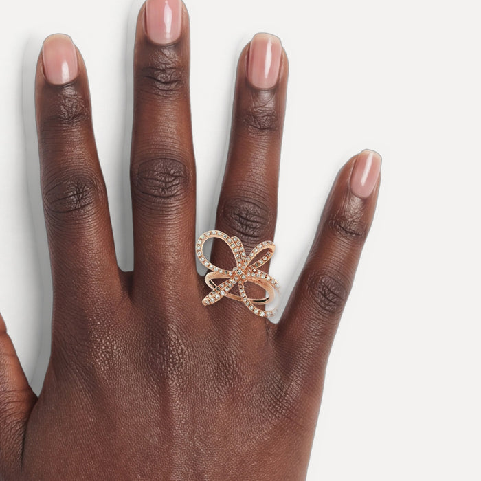 Colorless Round Brilliant Cut Diamond Pavé Set Ring (⅗ ct.) in 14k Rose Gold Bow shown on a hand (deep skin tone)