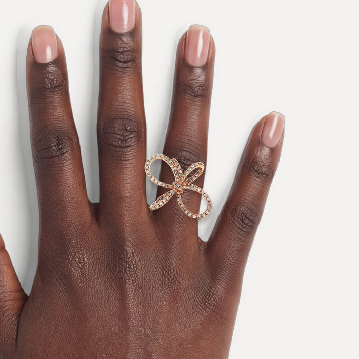 Colorless Round Brilliant Cut Diamond Pavé Set Ring (⅗ ct.) in 14k Rose Gold Bow shown on a hand (deep skin tone)