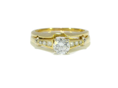Gold ring with a large diamond and smaller diamonds on a white background