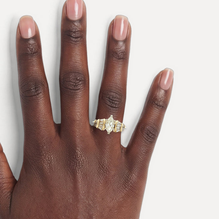 Marquise Brilliant Cut and Baguette Cut Diamond Engagement Ring (1 ⅒ ct.) in 18k Yellow Gold shown on a hand (deep skin tone)