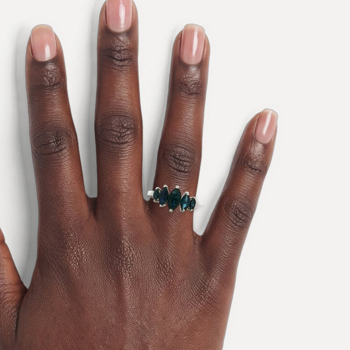Graduating Marquise Cut Deep Vivid Blue Sapphire Ring (2 ct.) in 14k White Gold shown on a hand (deep skin tone)