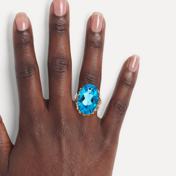 Vintage Oval-Shaped London Blue Topaz Ring (17 ct.) in 14k Rose Gold shown on a hand (deep skin tone)