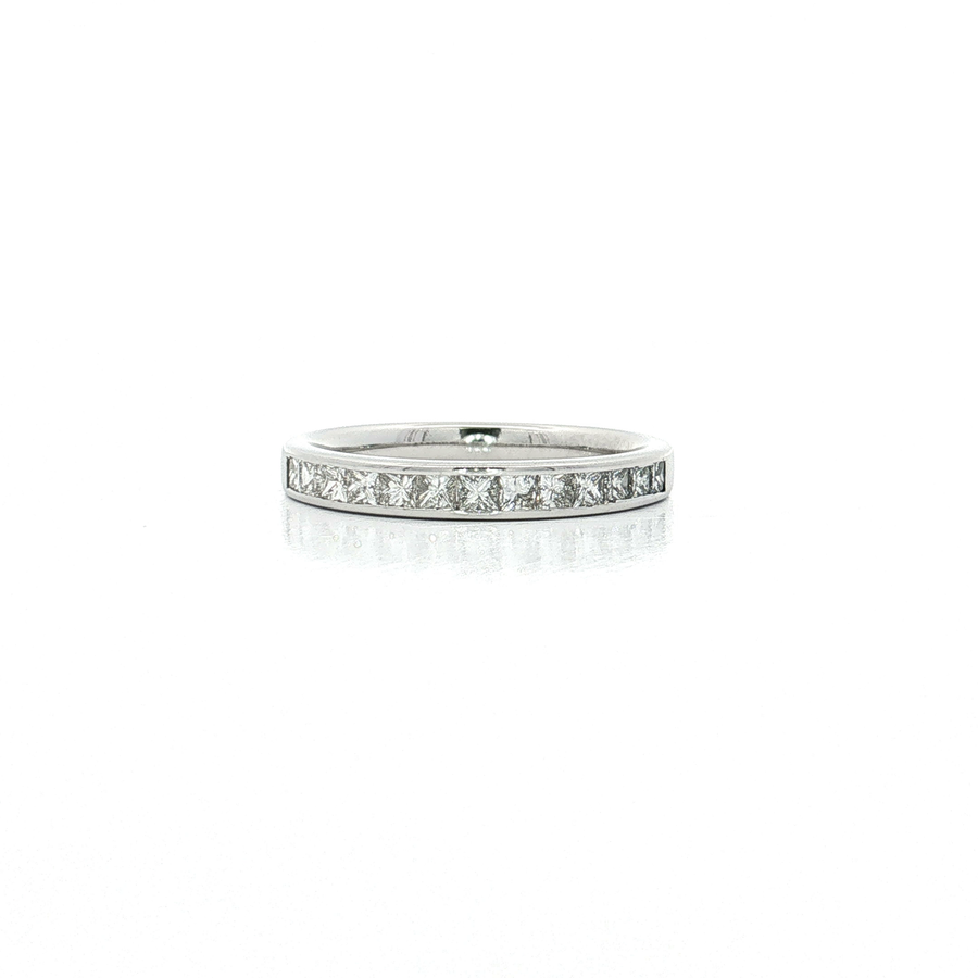 A silver diamond eternity ring with a continuous row of round-cut diamonds set in a polished silver band, shown on a reflective white surface.