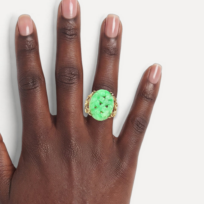 Vintage Large Hand Carved Oval Shaped Jade Ring in 14k Yellow Gold shown on a hand (deep skin tone)