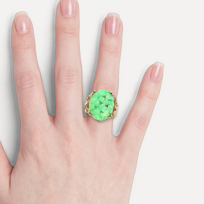 Vintage Large Hand Carved Oval Shaped Jade Ring in 14k Yellow Gold shown on a hand (light skin tone)