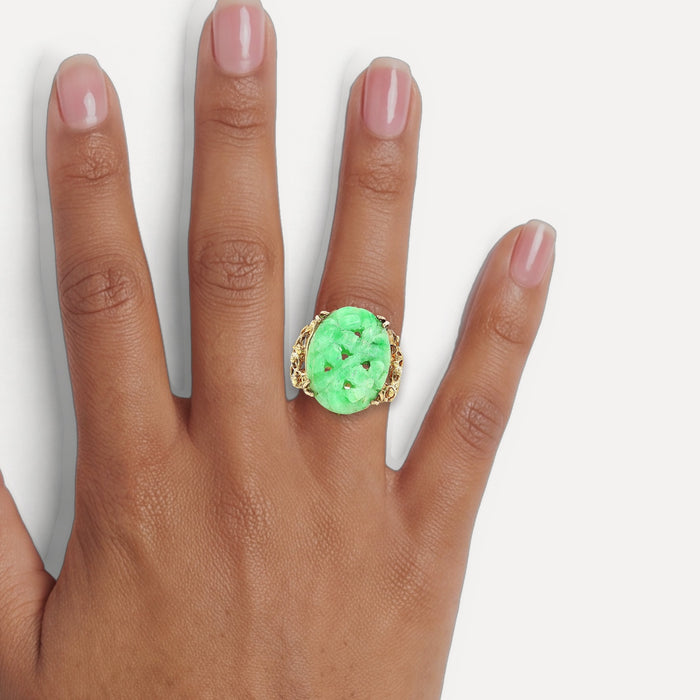 Vintage Large Hand Carved Oval Shaped Jade Ring in 14k Yellow Gold shown on a hand (medium deep skin tone)