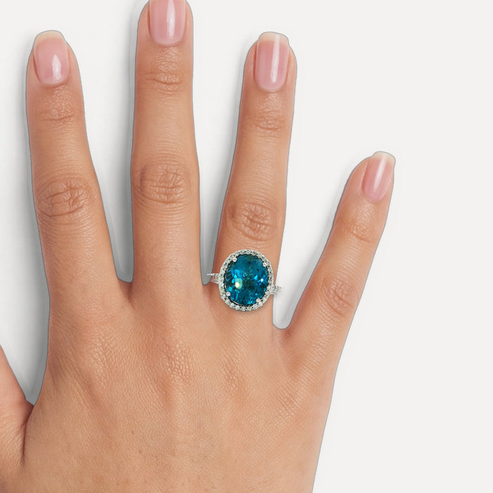 Oval-Shaped Deep London Blue Topaz & Colorless Diamond Halo Ring (7 ¼ ct. tw.) in 14k White Gold shown on a hand (medium skin tone)