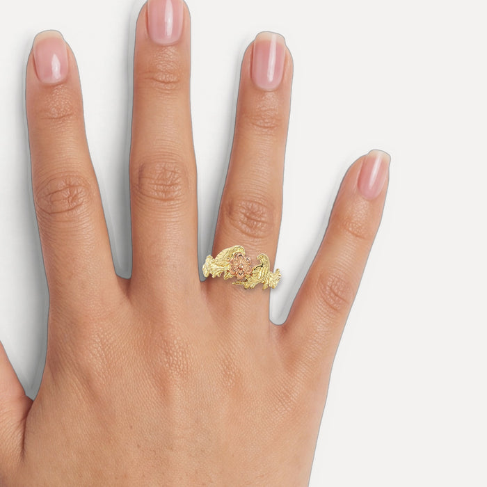Vintage Black Hills Gold Grape Leaf & Bird Ring in 14k Two-Tone Yellow and Rose Gold shown on a hand (medium skin tone)
