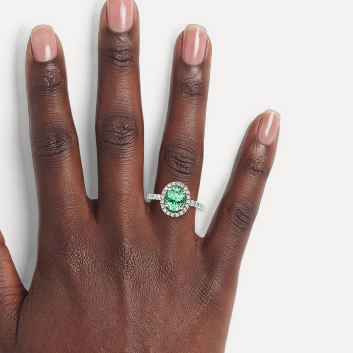 Oval Vivid Mint Green Demantoid Garnet Colorless Nearly Flawless Halo Diamond Ring (2 ⅓ ct. tw.) in 18k White Gold shown on a hand (deep skin tone)