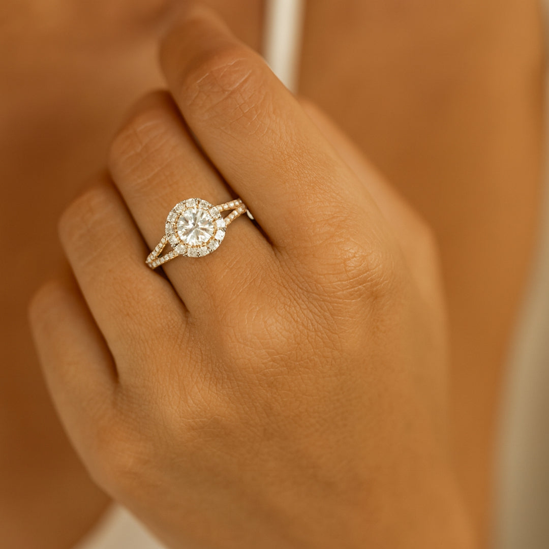 Round halo diamond engagement ring with split shank on woman's hand