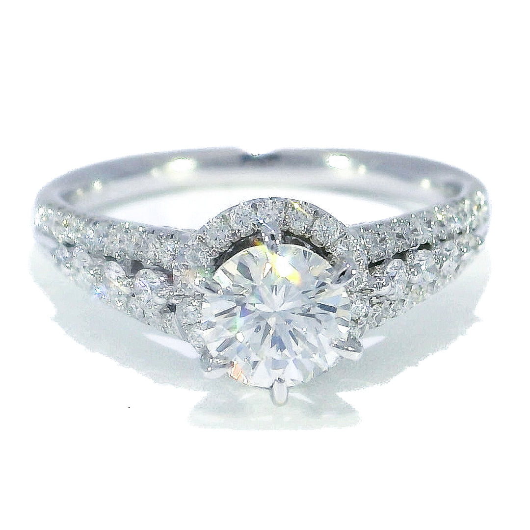 A round brilliant cut diamond engagement ring with a halo effect, set in a white gold band.
