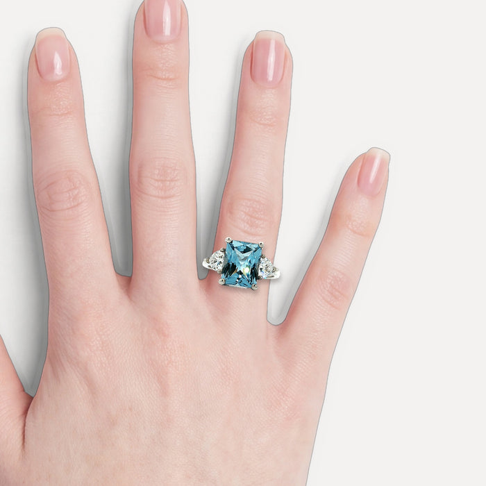 Radiant Cut Blue CZ Ring with Two Trillion Cut White Side CZs in Sterling Silver shown on a hand (light skin tone)