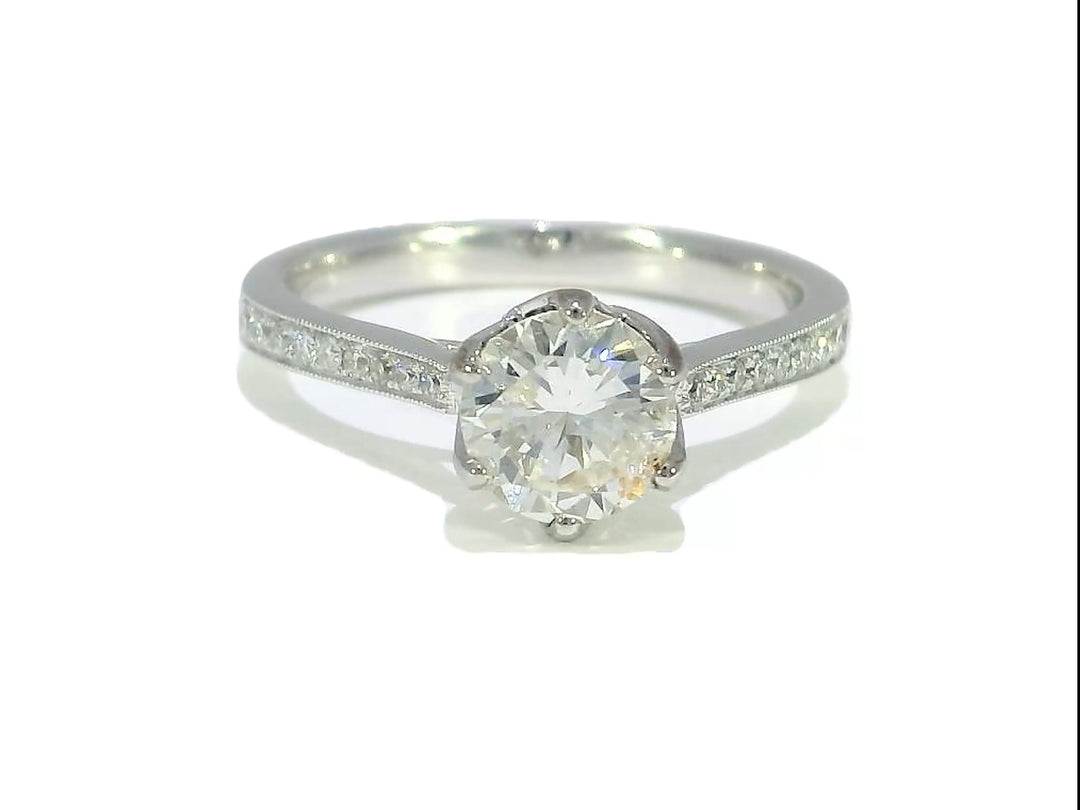 A 1.35 CTW Round Brilliant Diamond Engagement Ring in 18KT White Gold with a solitaire center stone and pavé-set Diamonds on the band.